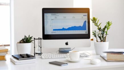 A clean, contemporary workspace featuring a desktop with analytics on the screen and plants for a fresh look.